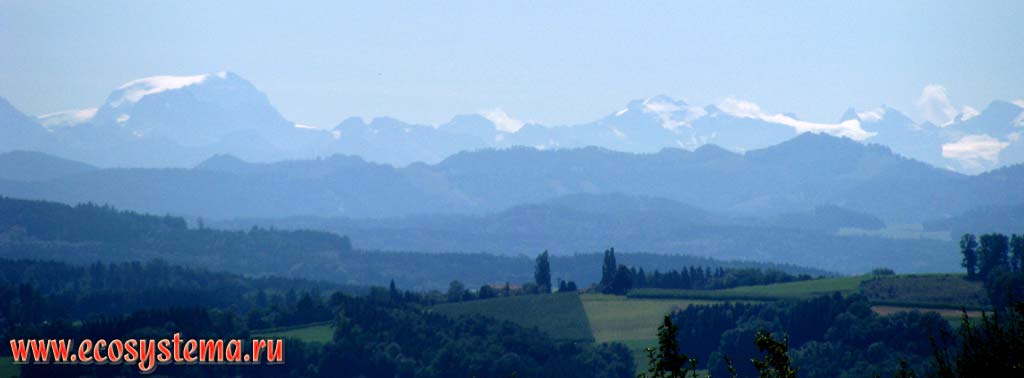 Вид на предгорья Западных Альп, покрытые широколиственными лесами, хребет Савойские Альпы и горный массив Монблан
(высоты вершин ок. 4000-4800 м н.у.м.) из Швейцарии