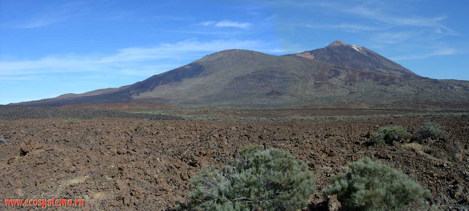 The panorama of the Las Canadas caldera with two volcanic cones: the Teide (Pico del Teide, 3718 meters height) and Pico Viejo (3134 meters height).
The lava age is 2000 years (red colour) and 300 years (black colour). Shooting point is at 2500 meters above sea level. Tenerife Island, Canary Archipelago