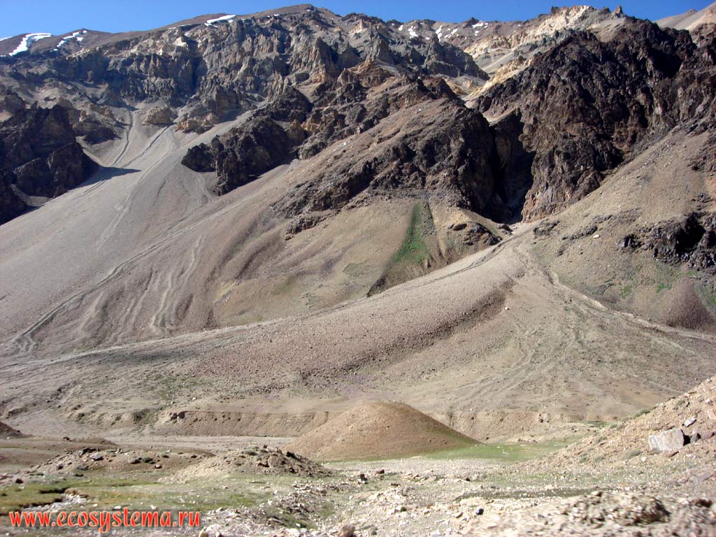 Альпийский рельеф: классические конусы выноса - накапливающийся у подножия гор делювий, результат активной денудации кристаллических и осадочных метаморфизированных горных пород в высокогорной пустыне Больших Гималаев. Высота около 5500 м над уровнем моря. Хребет Заскар (Занскар), штат Джамму и Кашмир, север Индии