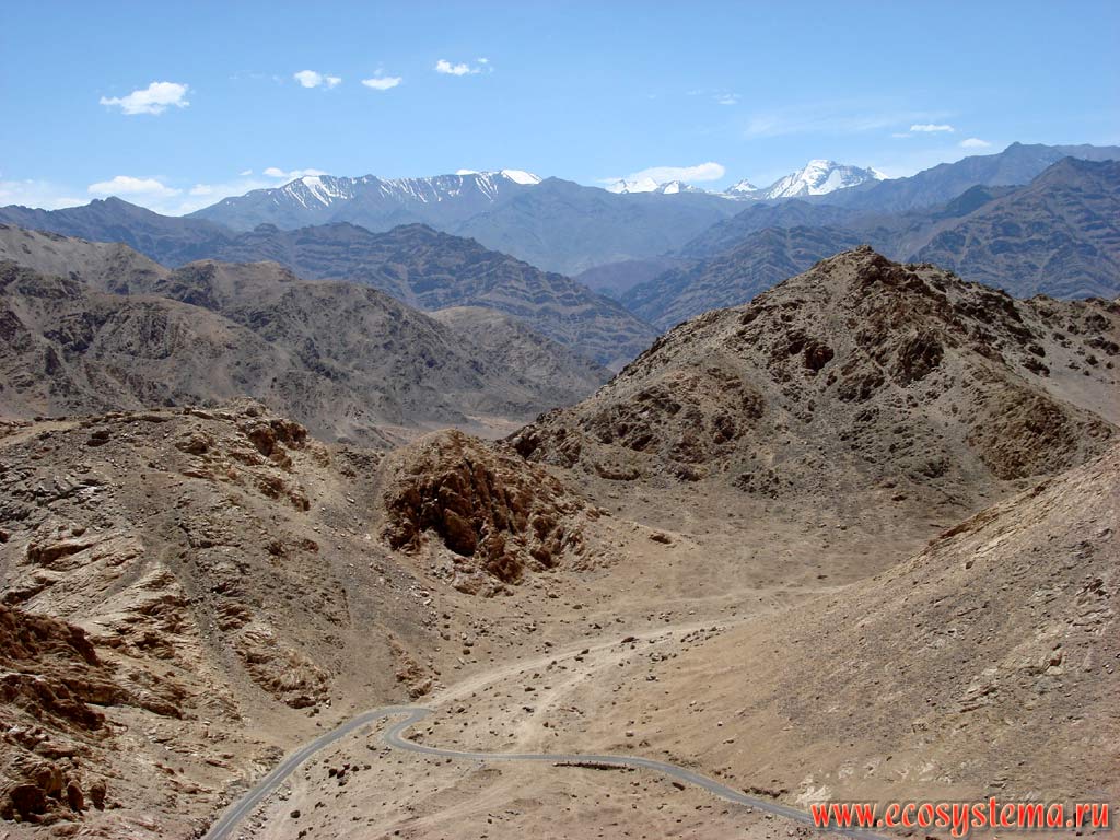 Альпийский рельеф на границе высокогорной пустыни и нивального пояса на вершинах хребта Заскар (Занскар) в Больших Гималаях. Вдали видна горизонтальная слоистость кристаллических и осадочных метаморфизированных горных пород. Высота около 4600 м над уровнем моря. Штат Химачал-Прадеш, север Индии