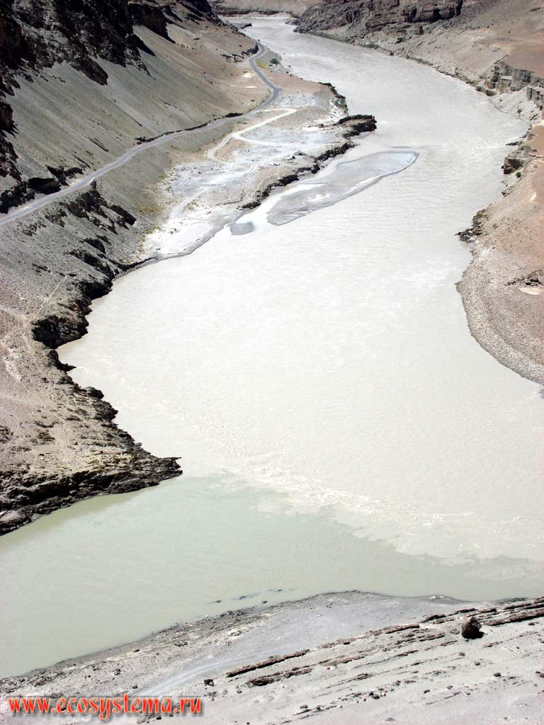 Слияние реки Инд (слева) и реки Занскар (справа) в окружении гор с аллювиальными отложениями и процессами активной денудации и осыпями. Большие Гималаи, область Ладакх, хребет Заскар (Занскар), высота около 4500 м над уровнем моря. Штат Химачал-Прадеш, север Индии