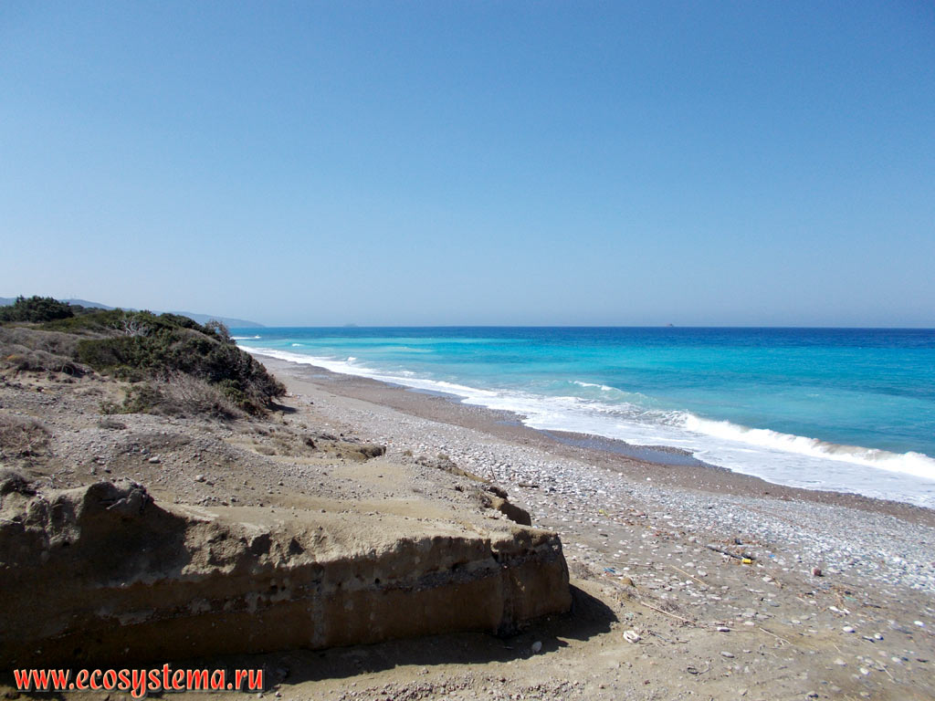 Прибой на песчано-галечном пляже и голубые воды Эгейского моря на западном побережье острова Родос