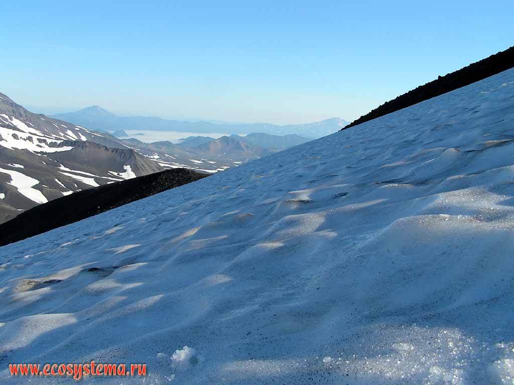 Snowfield on the Avachinsky volcano slope, covered by volcanic ashes