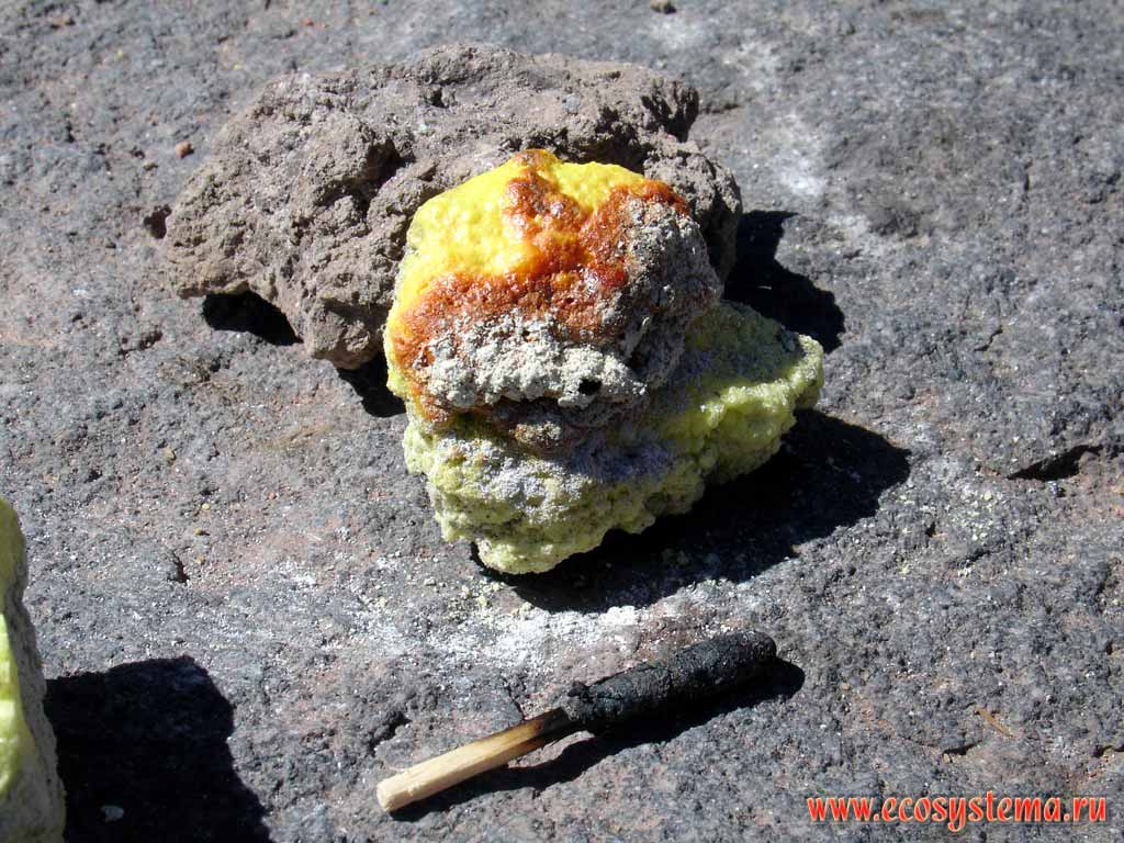Piece (rock) of a volcano sulfur. Hunter's match as a scale (7 cm)