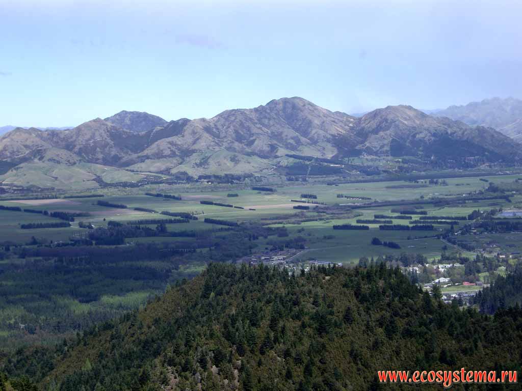 Вид на долину Ханмер Спрингс и горы Спенсера (Spenser Mountains).
Высота - 600 м над уровнем моря.
На переднем плане - Коническая гора (Conical Hill)
(регион Кентербери, восток Южного острова)