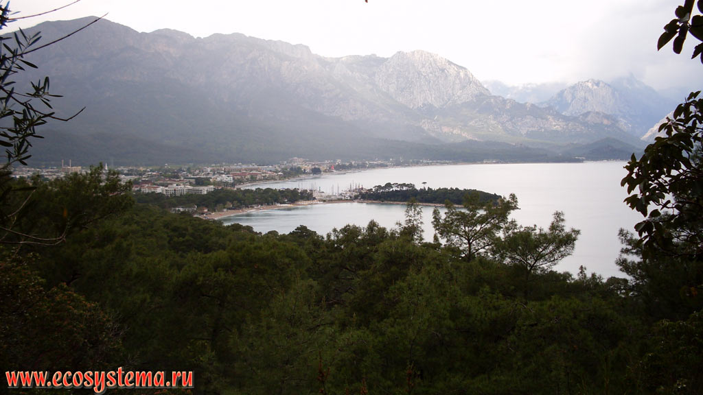 A view to the city of Kemer, the Mediterranean coast, with bays and promontories, covered with broad-leaved and light-coniferous (pine) forests, the slopes of the Beydaglari ridge